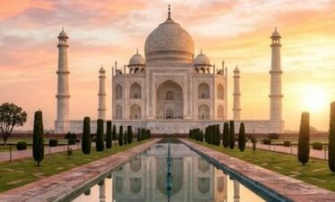 Majestic white marble Taj Mahal at sunrise reflecting in the pool in Agra